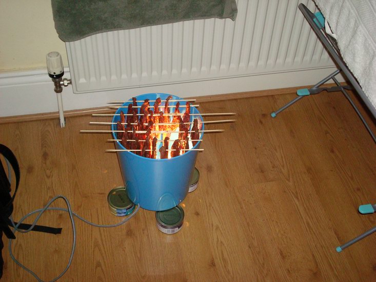 Sedan träs det upp på spett och hängs över glöden där det långsamt får torka